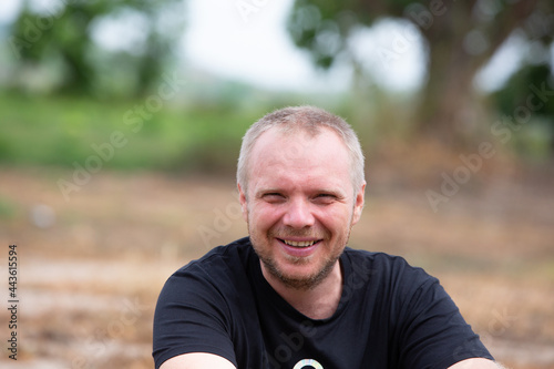 Portrait of smiling caucasian man sitting outdoors.