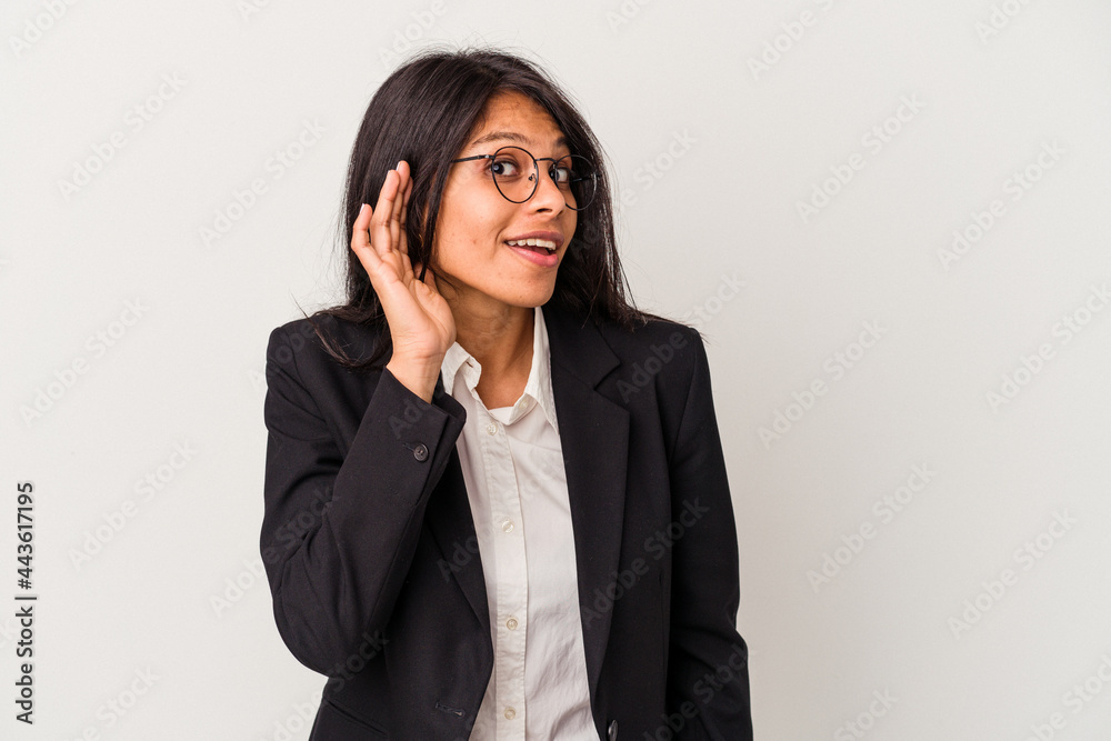 Young business latin woman isolated on white background trying to listening a gossip. Young business latin woman isolated on white background trying to listening a gossip.