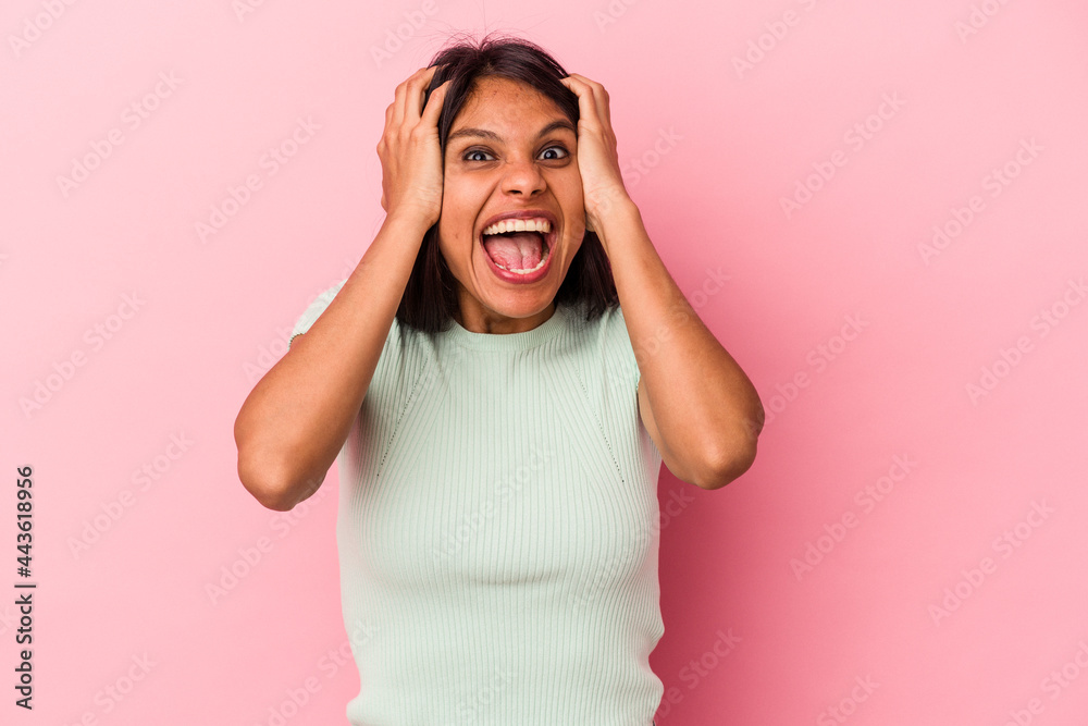 Young latin woman isolated on pink background screaming, very excited, passionate, satisfied with something. Young latin woman isolated on pink background screaming, very excited, passionate, satisfied with something.
