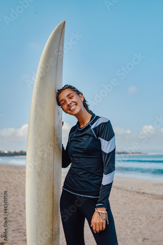 Photography Joyful woman with surfboard overlooking sea background