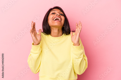 Young latin woman isolated on pink background laughs out loudly keeping hand on chest.