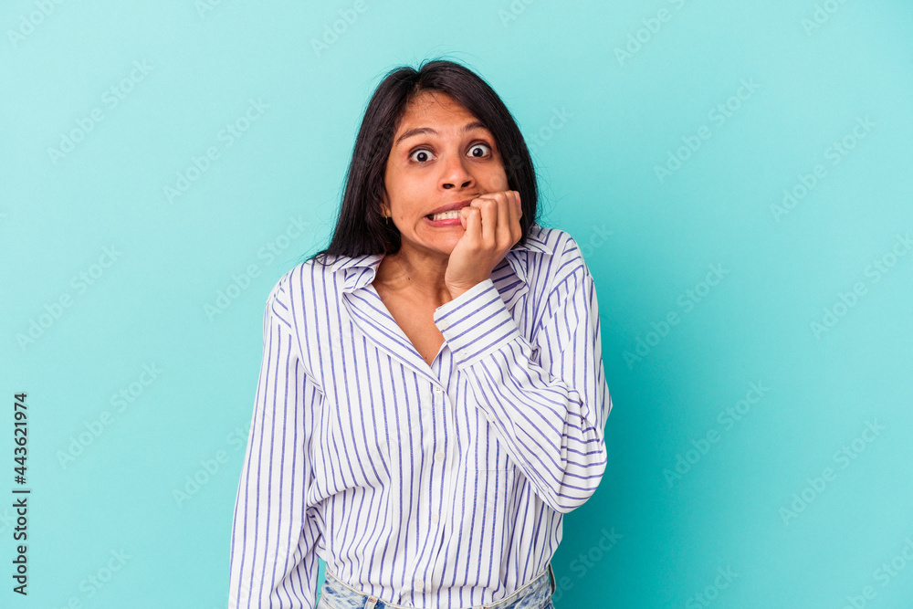 Young latin woman isolated on blue background biting fingernails, nervous and very anxious. Young latin woman isolated on blue background biting fingernails, nervous and very anxious.