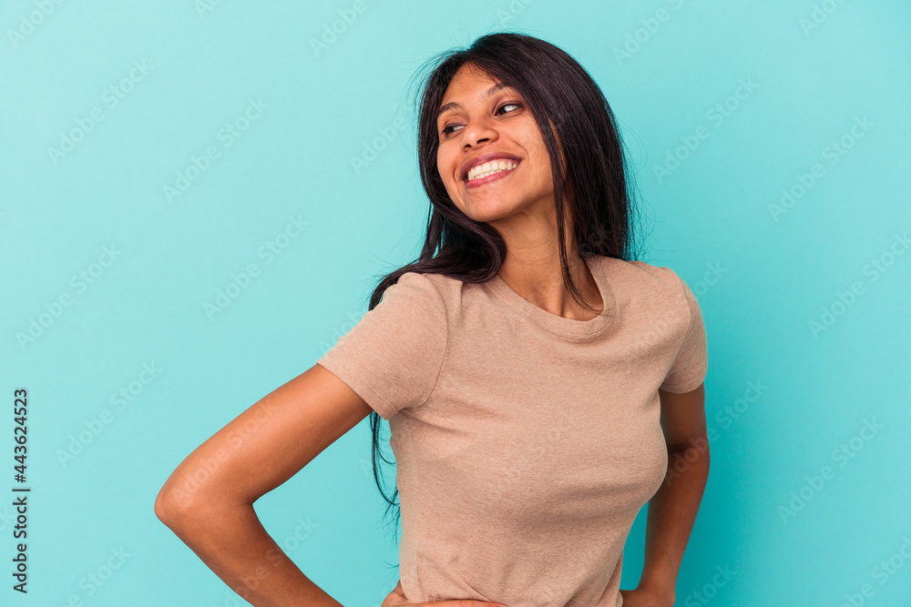 Young latin woman isolated on blue background laughs happily and has fun keeping hands on stomach. Young latin woman isolated on blue background laughs happily and has fun keeping hands on stomach.