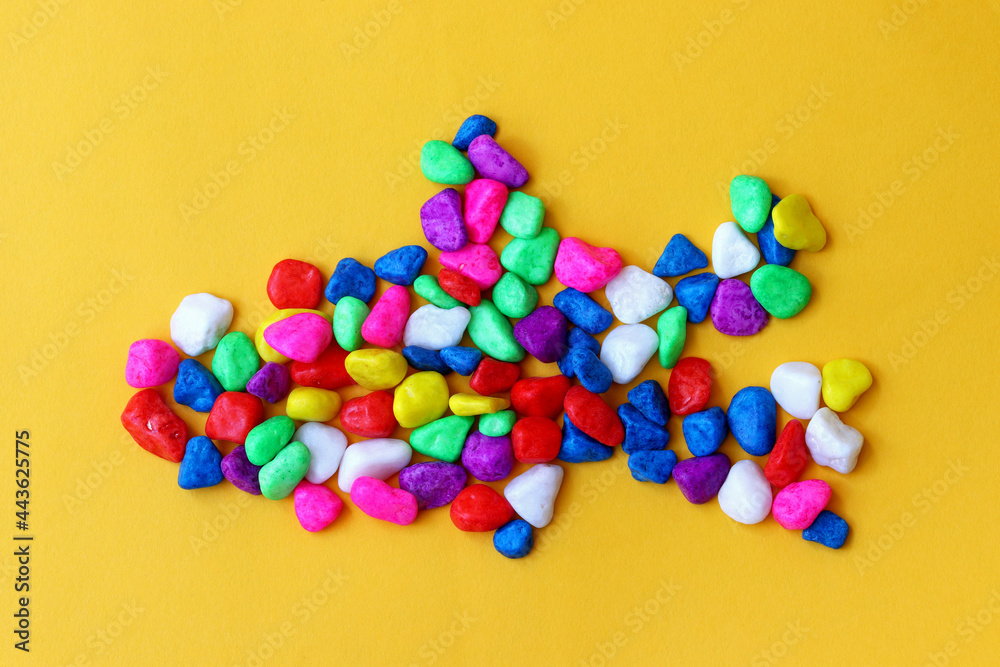 colored pebbles on yellow background colored pebbles on yellow background