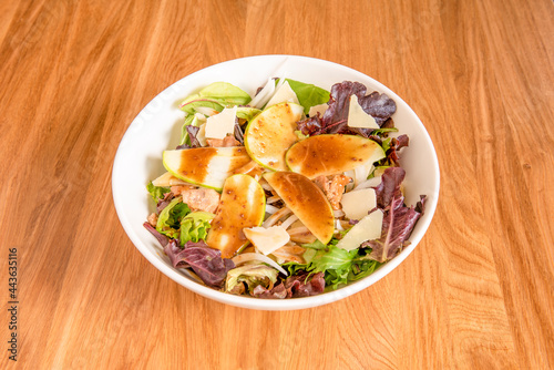 Sprout salad bowl with apple slices, white onion, canned tuna torozos and parmesan cheese flakes photo