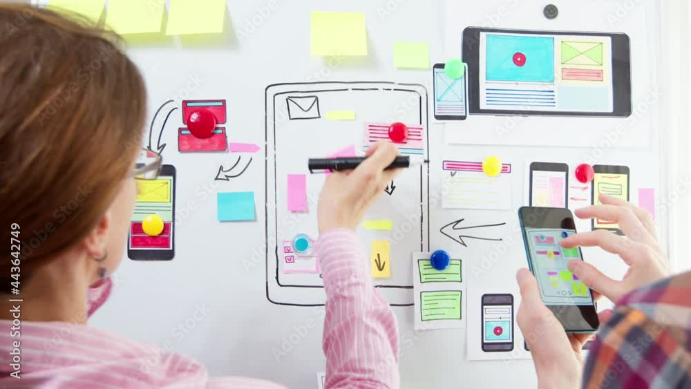 Designers are developing a web application for mobile phones. The creators are working on a sketch of the interface for the smartphone. User experience.