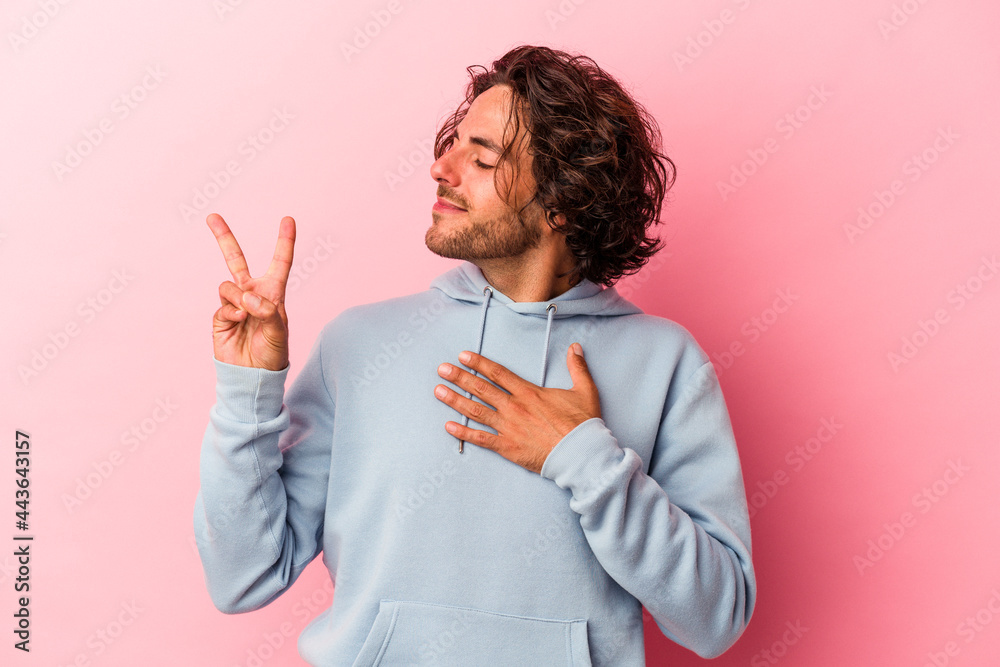 Young caucasian man isolated on pink bakcground taking an oath, putting hand on chest. Young caucasian man isolated on pink bakcground taking an oath, putting hand on chest.