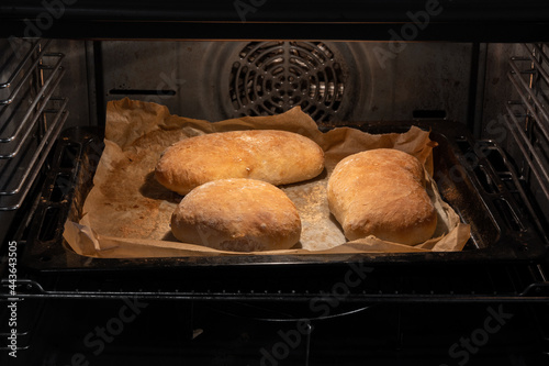 Baking breads in home oven. Homemade fresh baked pita breads.