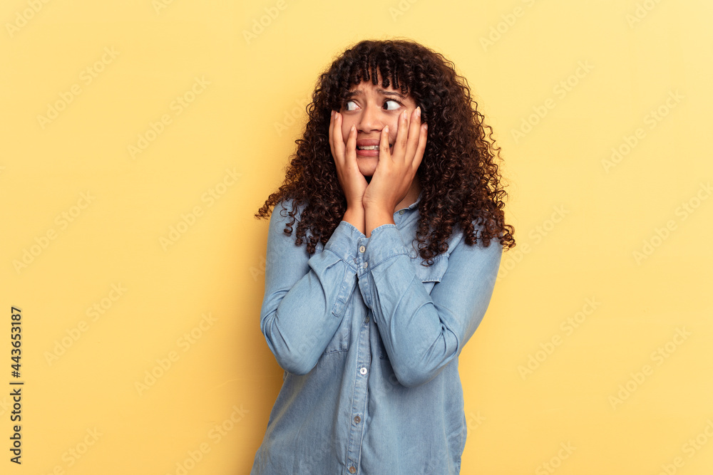 Young mixed race woman isolated on yellow background scared and afraid. Young mixed race woman isolated on yellow background scared and afraid.