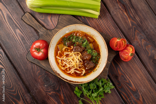 lagman with beef in tomato sauce in a deep plate, photo for the menu photo