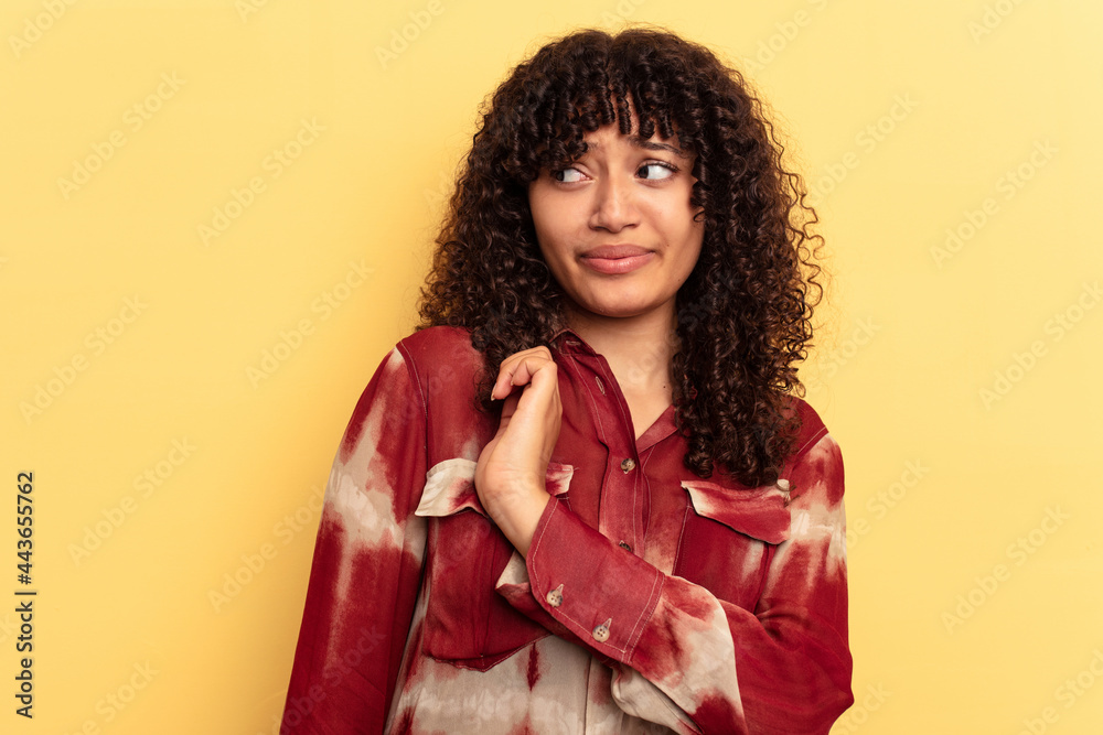 Young mixed race woman isolated on yellow background confused, feels doubtful and unsure. Young mixed race woman isolated on yellow background confused, feels doubtful and unsure.