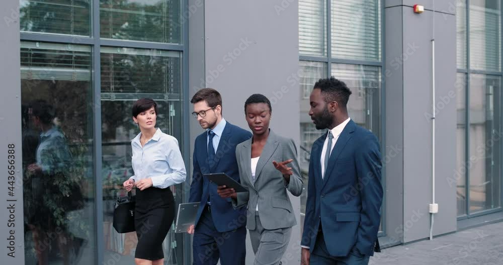 Cheerful diverse colleagues are discussing certain case. Woman telling something, her colleagues looking at her with smile. Business team concept Cheerful diverse colleagues are discussing certain case. Woman telling something, her colleagues looking at her with smile. Business team concept