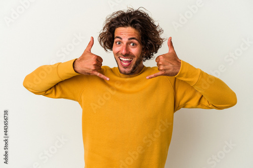 Young caucasian man isolated on white background showing a mobile phone call gesture with fingers.