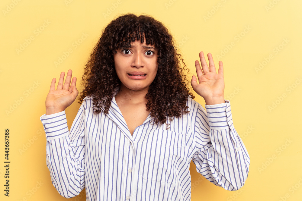 Young mixed race woman isolated on yellow background being shocked due to an imminent danger Young mixed race woman isolated on yellow background being shocked due to an imminent danger