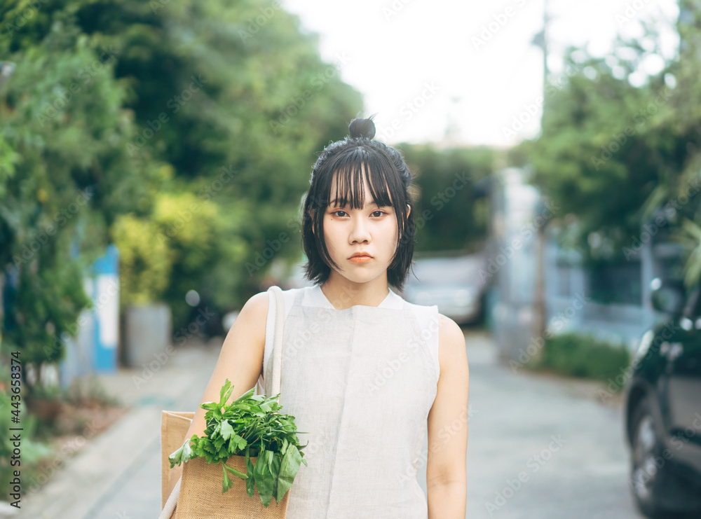 Portrait young adult asian woman hand holding cloth bag with vegetable food for wellness lifestyle.