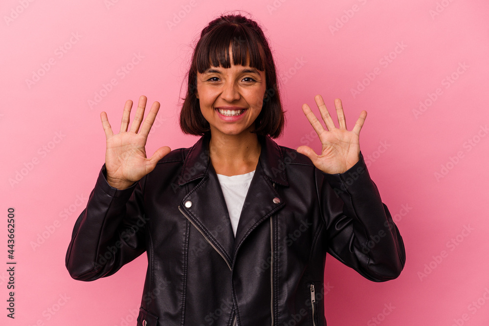 Young mixed race woman isolated on pink background showing number ten with hands. Young mixed race woman isolated on pink background showing number ten with hands.