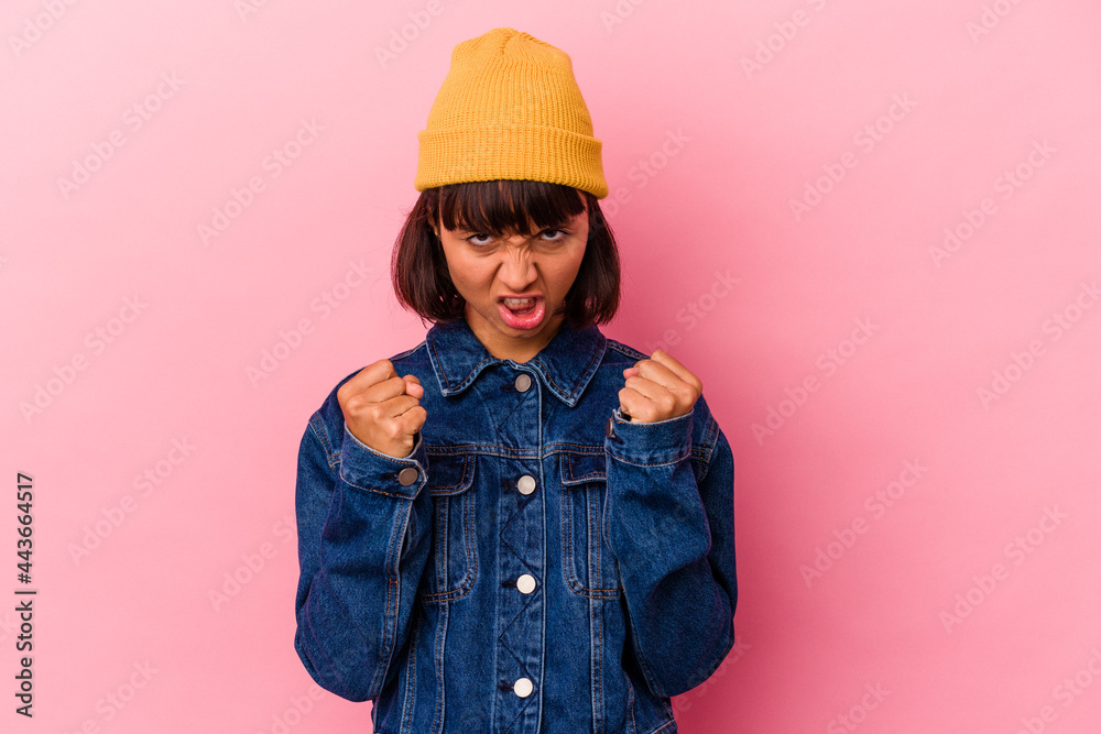 Young mixed race woman isolated on pink background upset screaming with tense hands. Young mixed race woman isolated on pink background upset screaming with tense hands.