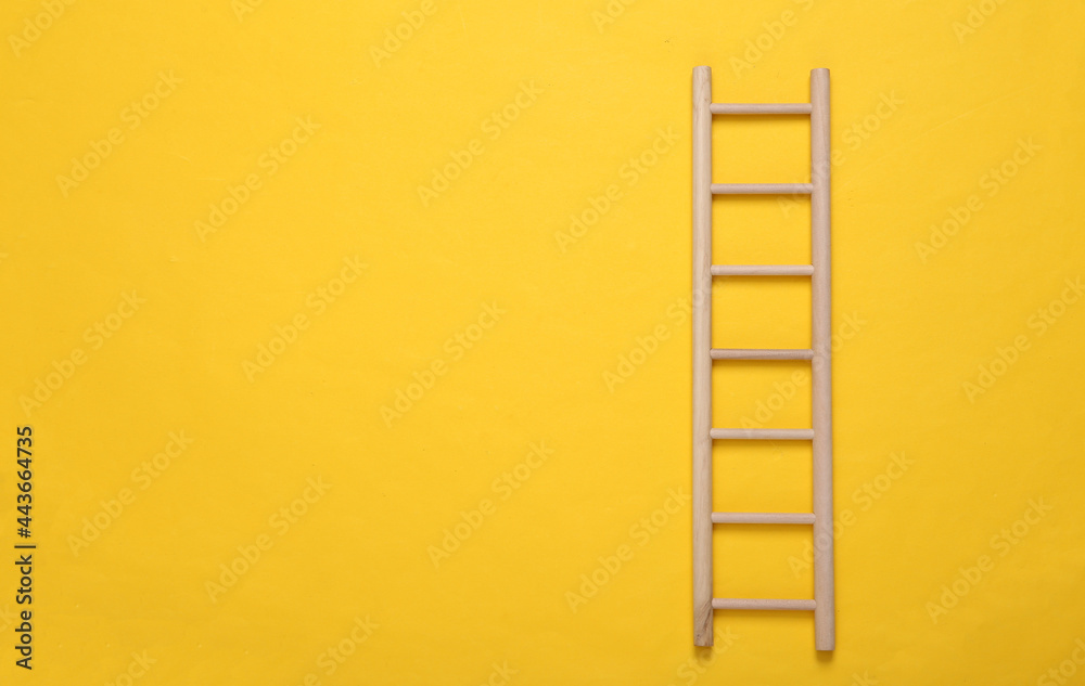 Wooden staircase on yellow background.