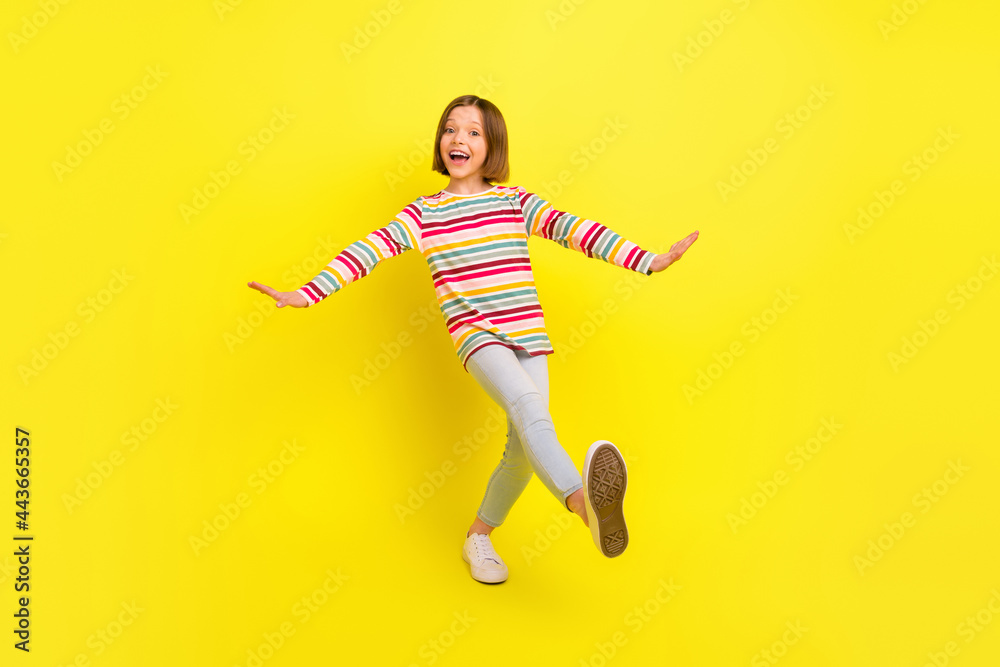 Full body photo of cheerful young positive small girl dance funny funky mood isolated on yellow color background