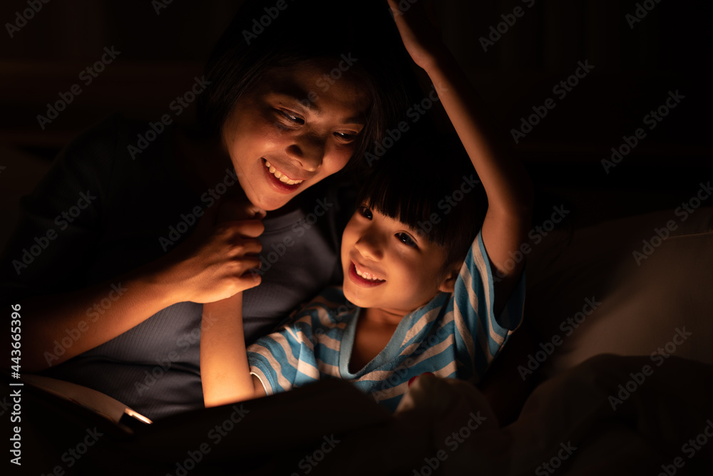 asian parent bedtime with kid, mom playing with child, Mother and daughter enjoying on the bed, happy, smiling to each other, family quality time concept .