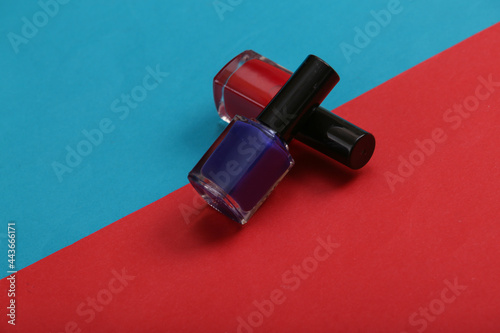 Nail polish bottles on red blue background.