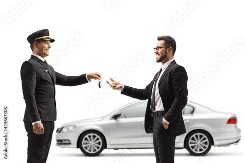 Valet returning car keys from a silver car to a businessman photo