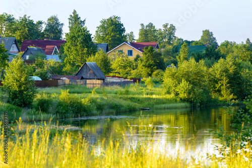 Rural landscape by the river, village in summer