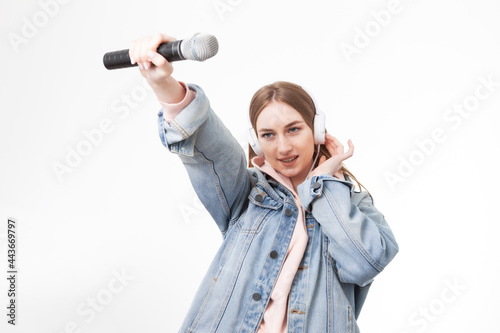Young happy caucasian woman with headphones holding microphone isolated on white background