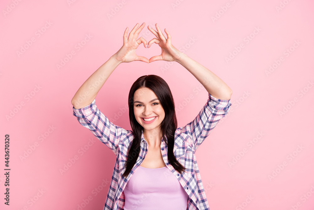 Photo of peaceful coquette girlfriend make heart symbol wear plaid shirt isolated on pink color background Photo of peaceful coquette girlfriend make heart symbol wear plaid shirt isolated on pink color background