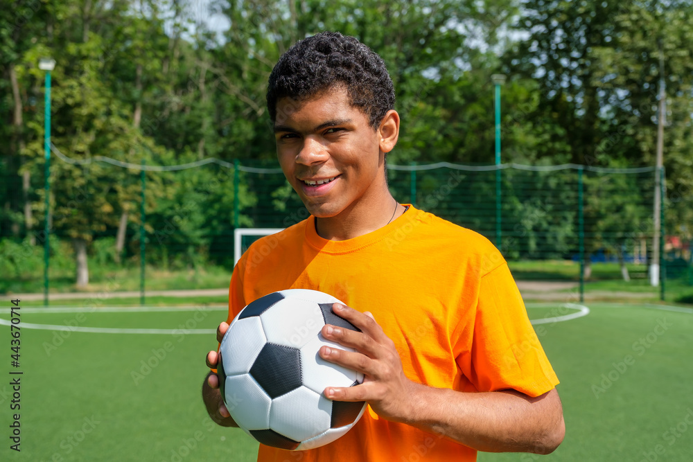 Brazilian man holding soccer ball while standing on sports court Brazilian man holding soccer ball while standing on sports court