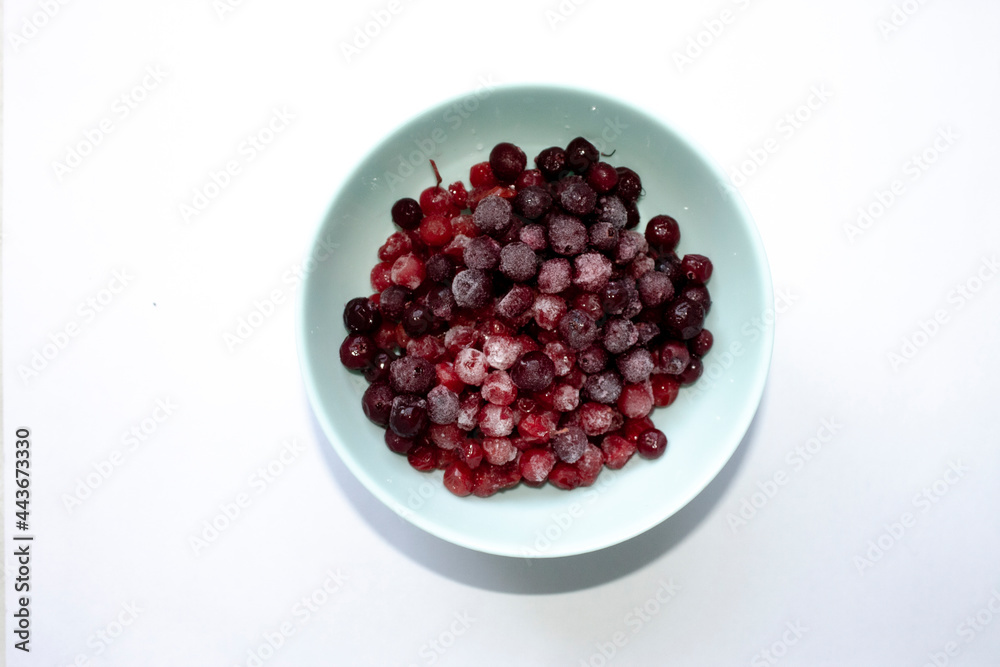 unfocused blue cup with frozen cranberries unfocused blue cup with frozen cranberries