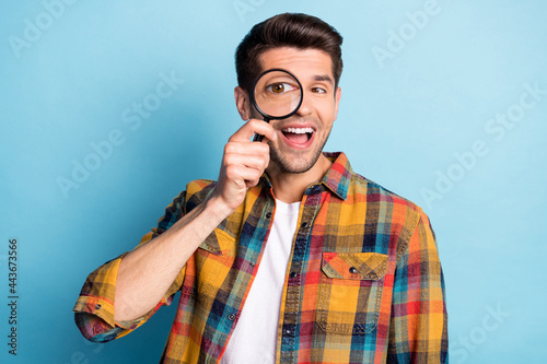 Valokuvatapetti Portrait of attractive cheerful guy holding in hand enlarge glass looking spy is