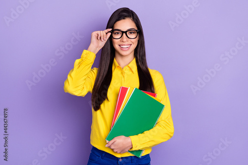 Photo of attractive charming young woman wear glasses hold materials student isolated on purple color background
