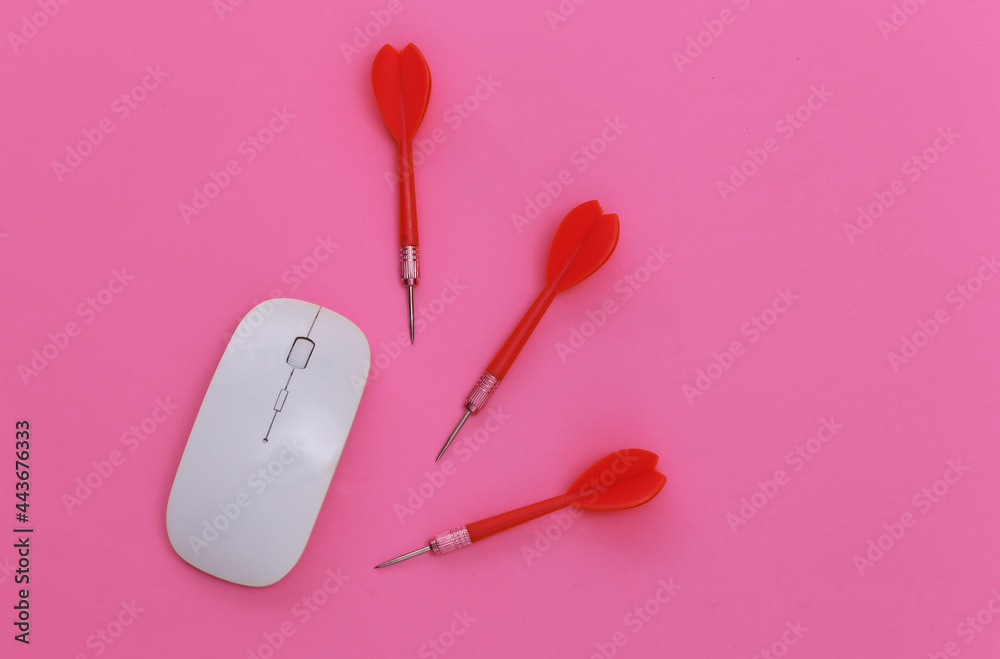 Pc mouse and darts on pink background. Top view Pc mouse and darts on pink background. Top view