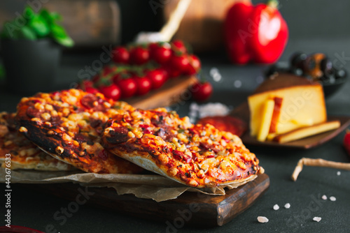 Pizza. Mini italian pizzas with cheese, pepper and tomatos. Pizza on wooden plate.