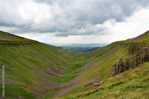 View of mouth of High Cup Nick a U-shaped valley in the northern Pennines in Cumbria, England, with the grey-blue dolerite crags seen on the right hand side photo