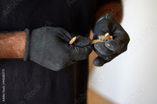 gloved hands sharpening a pencil close up