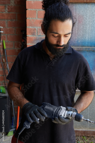 portrait of worker with a drill looking down