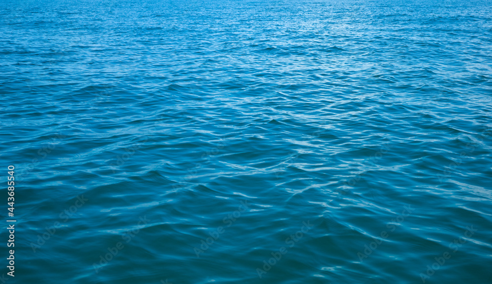 Fototapeta premium Blue water with sun reflections