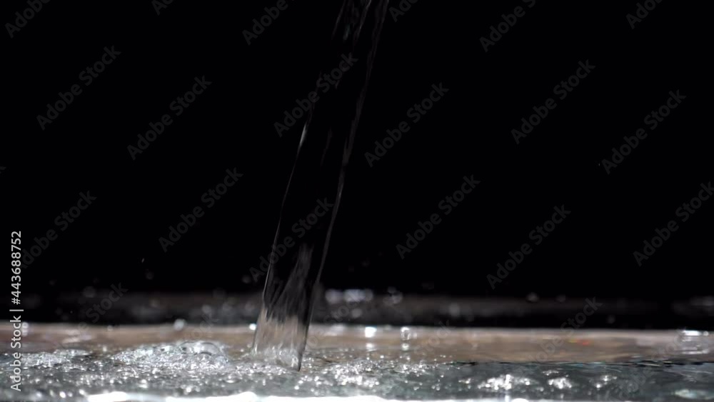 Slow motion stream o crystal clear of water drops down in aquarium on a black background Slow motion stream o crystal clear of water drops down in aquarium on a black background