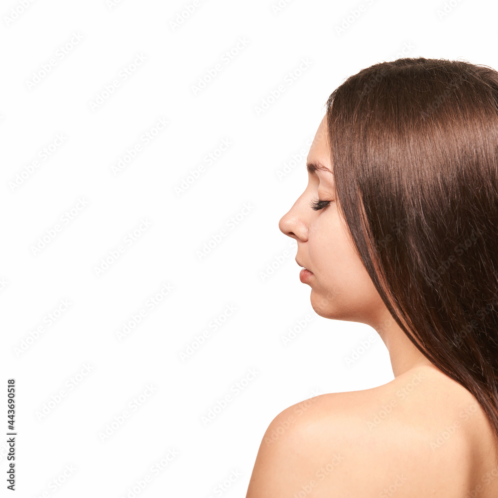 Young woman tail. Closed eeye female portrait. Isolated whire background. Brown long hair Young woman tail. Closed eeye female portrait. Isolated whire background. Brown long hair