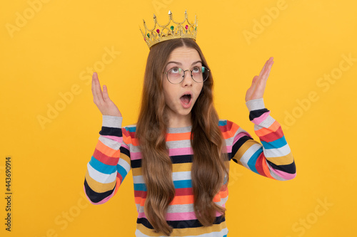 Tableau sur toile surprised egoistic kid in glasses wear queen crown on yellow background, surpris