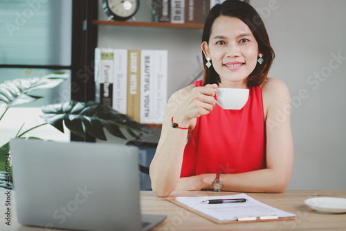 Happy beautiful woman working on wooden table with laptop and coffee cup. at work at home work from home concept 