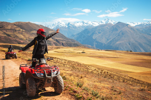 a person on a red quad happy looking to a beautiful view and rising a hand photo