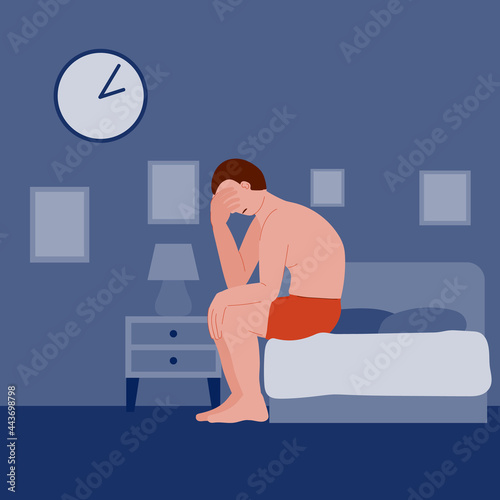man is suffering from insomnia. the man sits in bed and cannot sleep due to depression, stress, anxiety, illness, pain and trouble. a sleepless night. nightmare and awakening. bedroom interior.