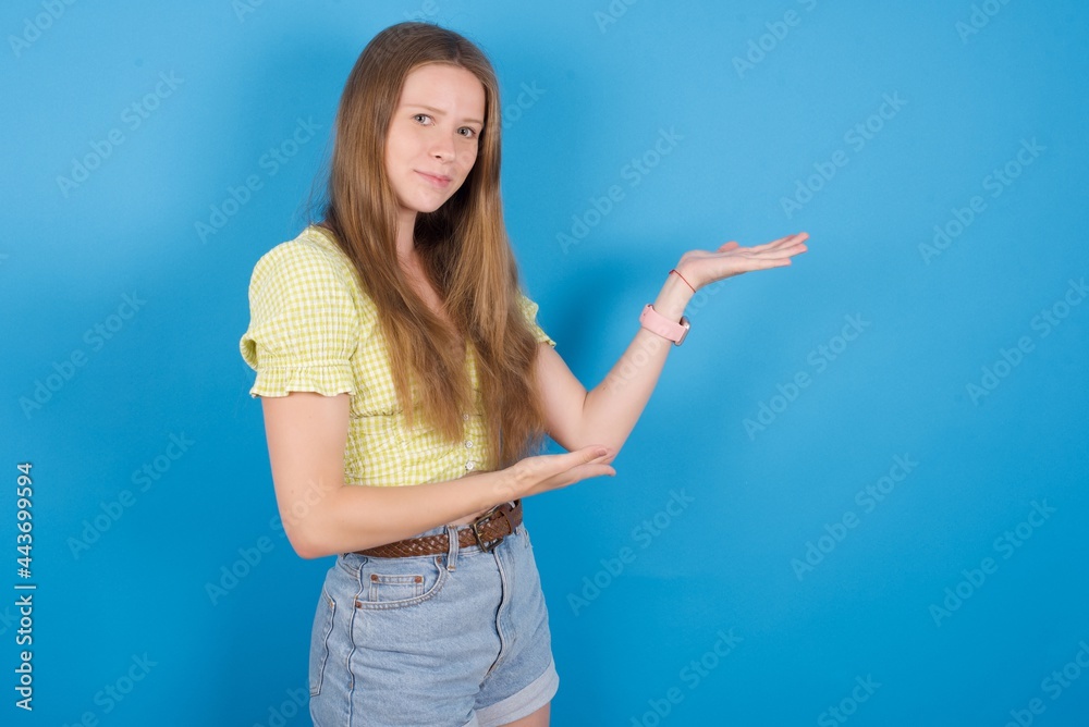 young beautiful blonde woman standing against blue background Inviting to enter smiling natural with open hands. Welcome sign. young beautiful blonde woman standing against blue background Inviting to enter smiling natural with open hands. Welcome sign.