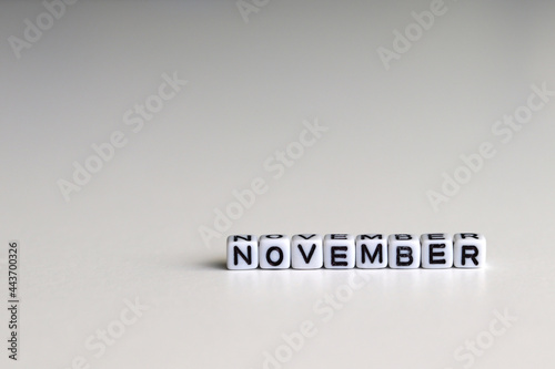 NOVEMBER is a word written on a white block. NOVEMBER is the word for your design, concept. Beautiful bokeh in the background