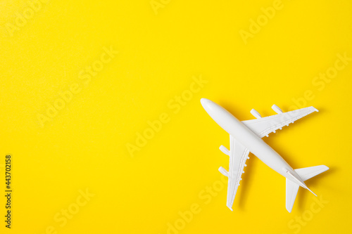 Flat lay design of travel concept with plane on yellow background.