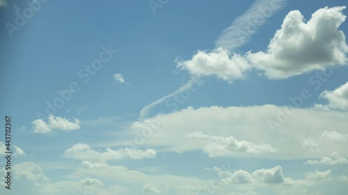 The white clouds in the sky move beautifully and softly, shot with Time Lapse in a tall building. The view is slightly tilted up against the clouds.