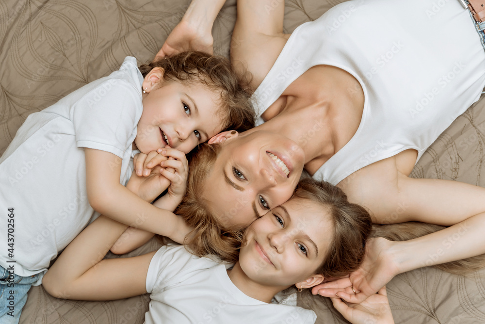 family portrait of a mother and three daughters lying down, top view. the concept of a happy motherhood and childhood family portrait of a mother and three daughters lying down, top view. the concept of a happy motherhood and childhood